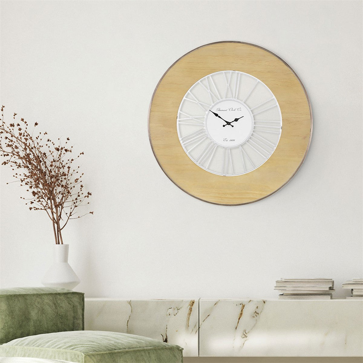 Wall with a round wooden clock and a vase with dried flowers.