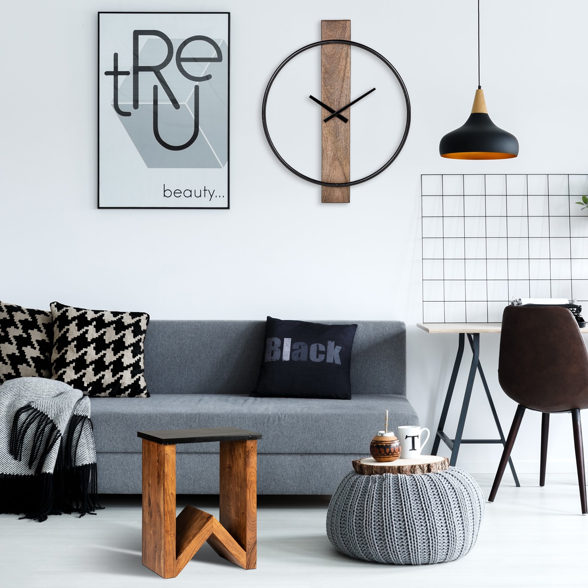 Wohnzimmer mit grauem Sofa, Wandkunst, Uhr und Tisch.