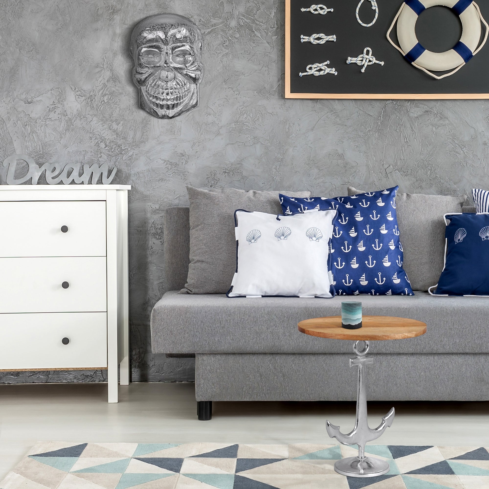 Wohnzimmer mit grauer Wand, Sofa, Kissen, Tisch und Teppich.