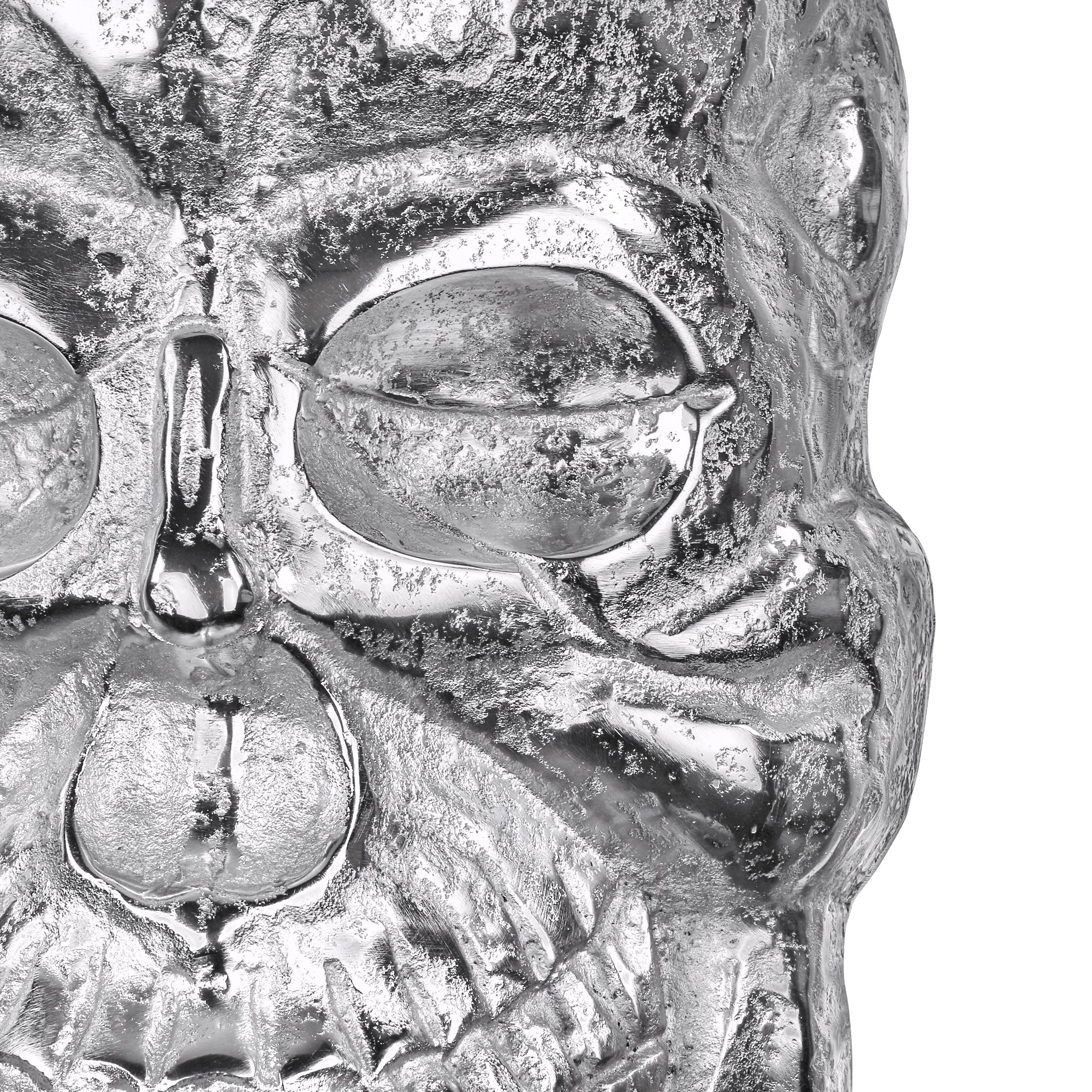 Metallische Skulptur eines Schädels mit Augen und einer Zigarette.