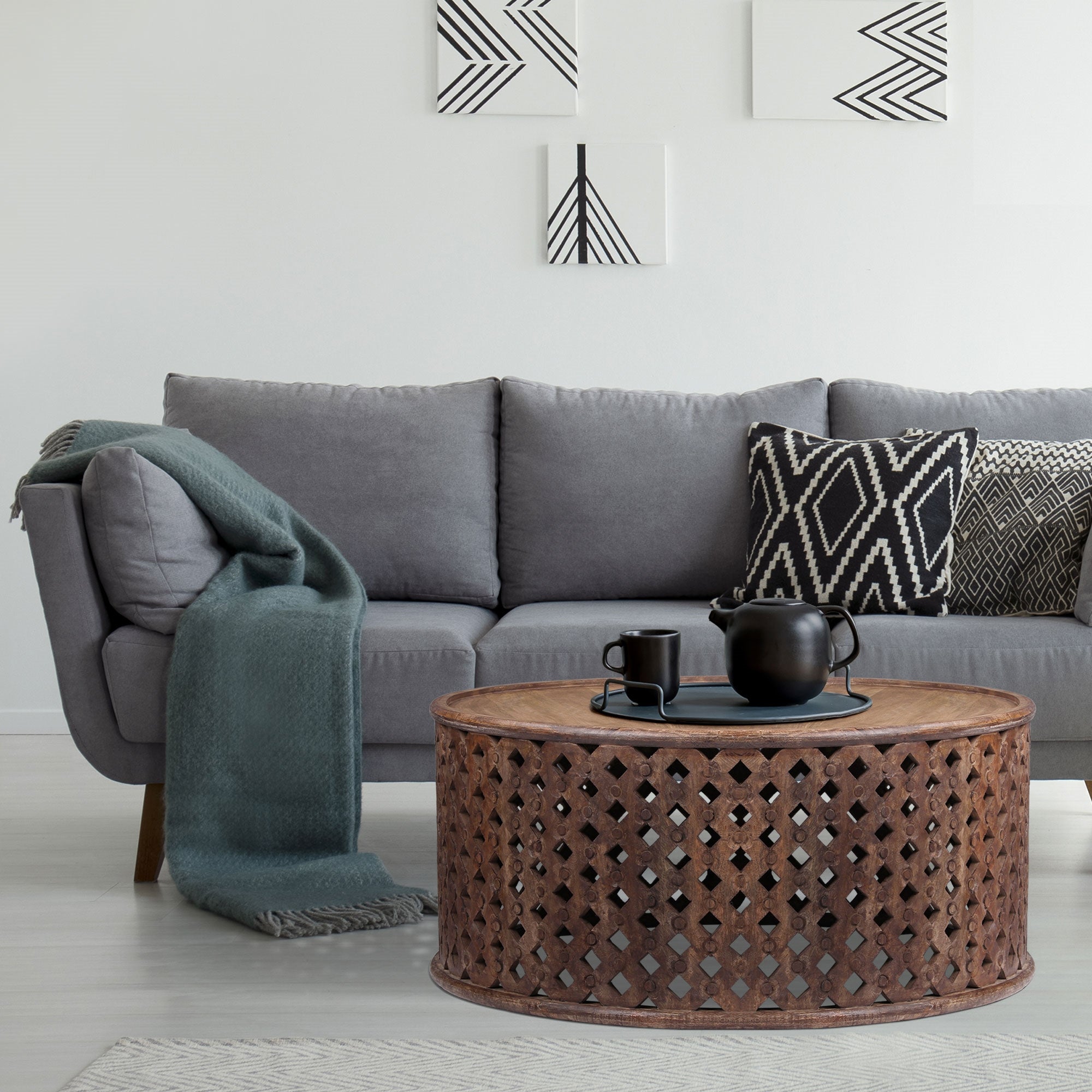 Soggiorno con divano grigio, tavolo da caffè e cuscini decorativi.