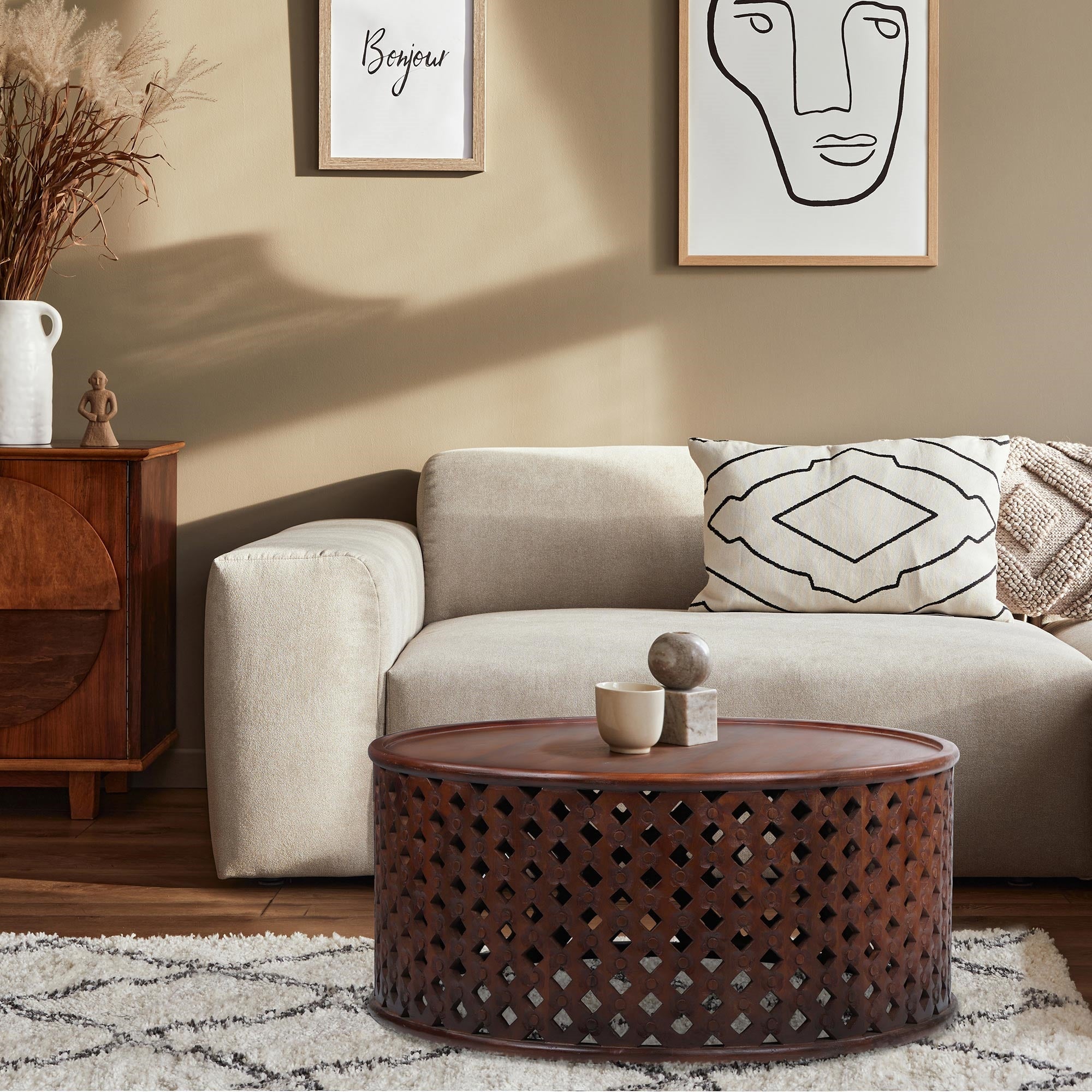 Wohnzimmer mit Sofa, Couchtisch und Wandbildern.