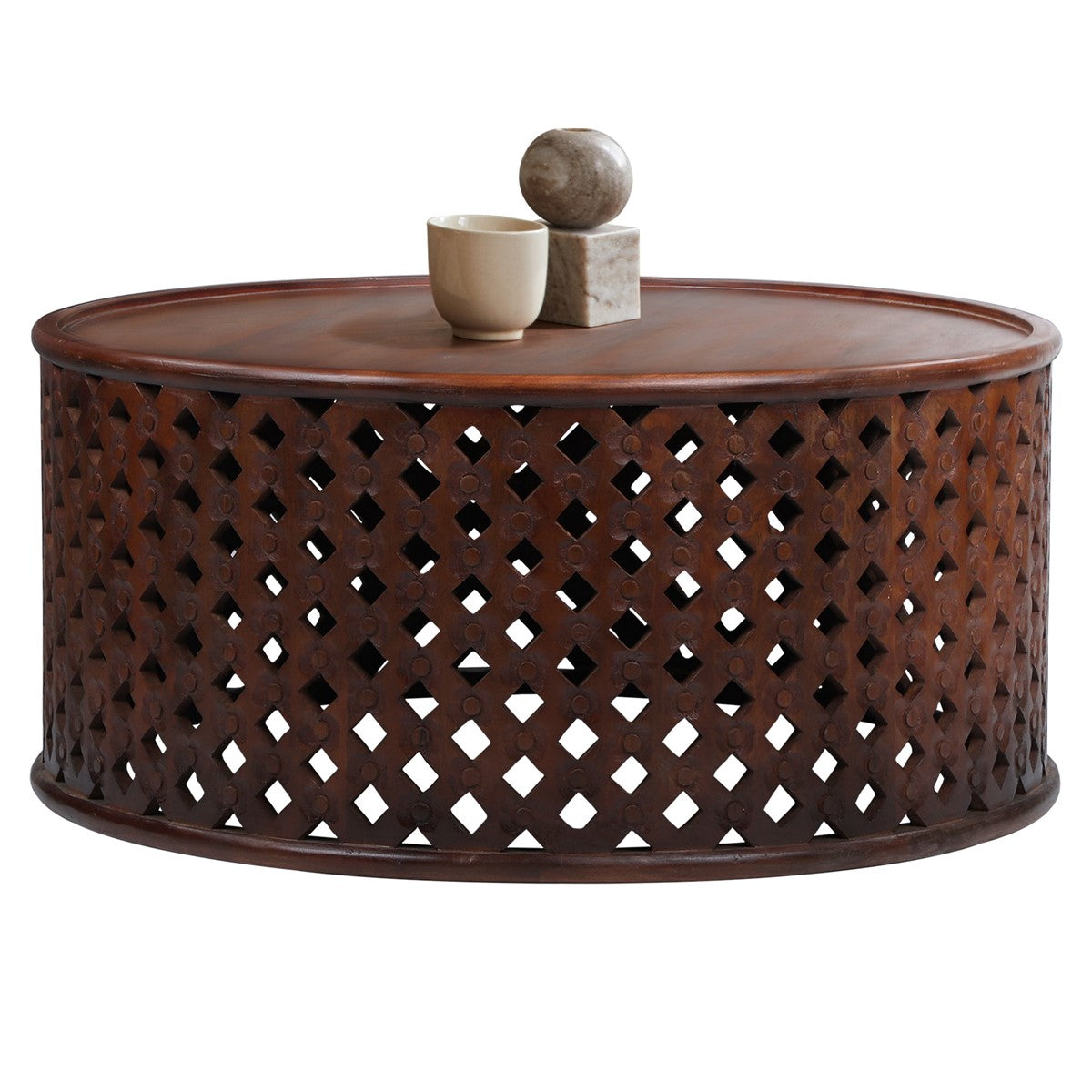 Round coffee table with a lattice pattern and two decorative objects on the surface.
