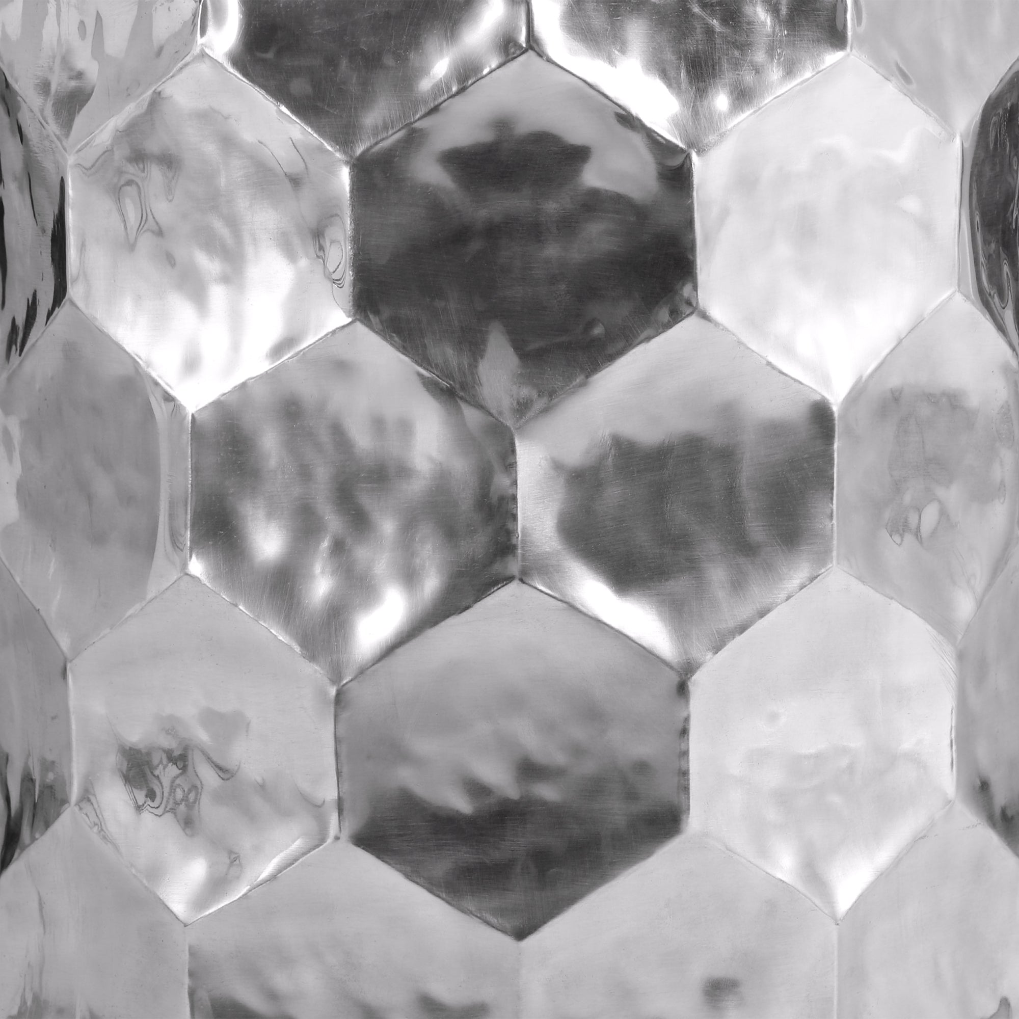 Metal surface with hexagonal patterns in shiny silver.